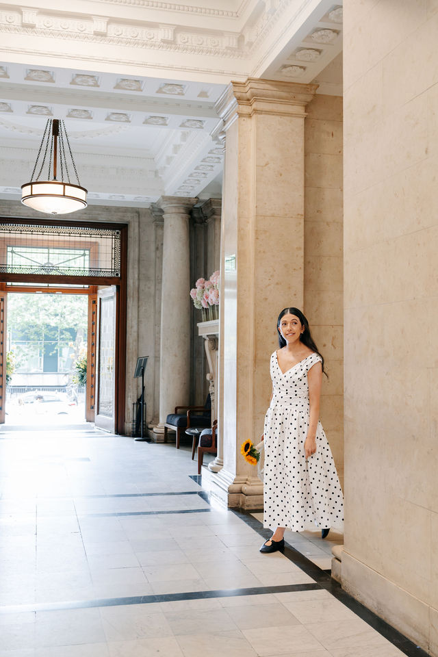 Frankie in her polka-dot wedding dress in the marble hallway